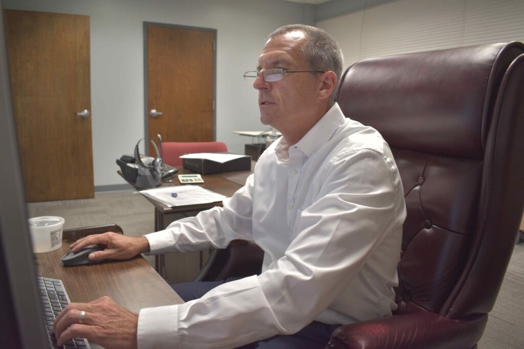 Jim Crean, Chief Operating Officer, at desk.